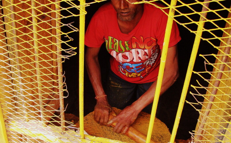 Man Preparing Sandalwood Saffron Paste for Devotees nearby Garud Shila, Badrinath, Uttarakhand, India