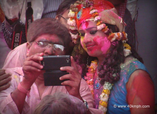Watching Holi Photos on Mobile during Lathmar Holi – 2014 at Barsana, Uttar Pradesh, India