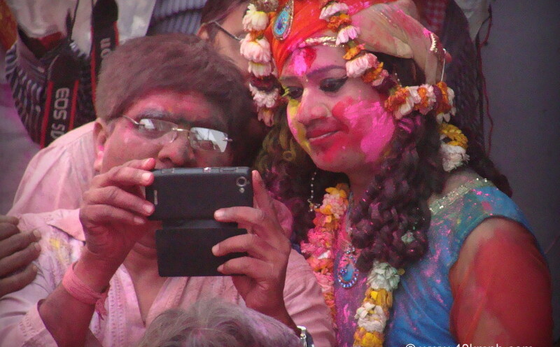 Watching Holi Photos on Mobile during Lathmar Holi – 2014 at Barsana, Uttar Pradesh, India