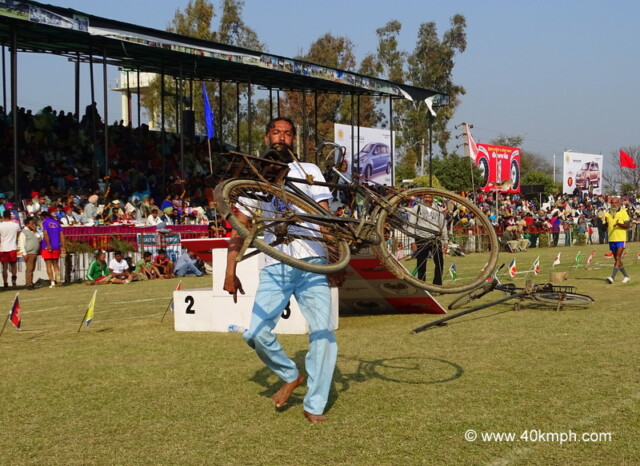 Man Lifting Cycle with Teeth at 79th Kila Raipur Sports Festival 2015 in Punjab, India