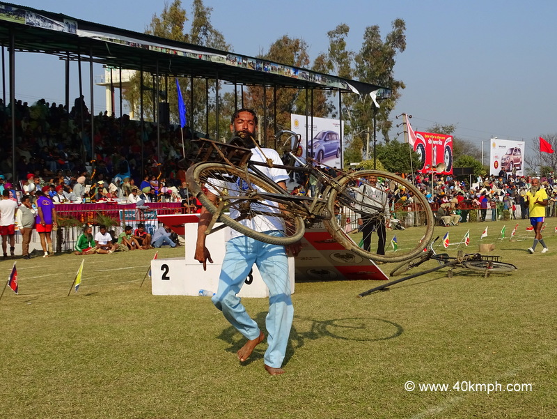 Man Lifting Cycle with Teeth at 79th Kila Raipur Sports Festival 2015 in Punjab, India